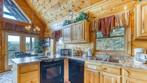 A wooden cabin kitchen with a central island, built-in appliances, and large windows. - Spacious, Dog Welcome Cabin, Sleeps 8・Mtn Views (Pigeon Forge)