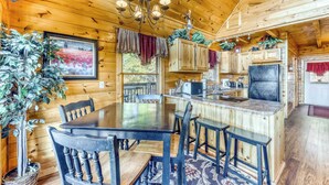 A wooden cabin interior with a dining area, kitchen, and bar. - Spacious, Dog Welcome Cabin, Sleeps 8・Mtn Views (Pigeon Forge)