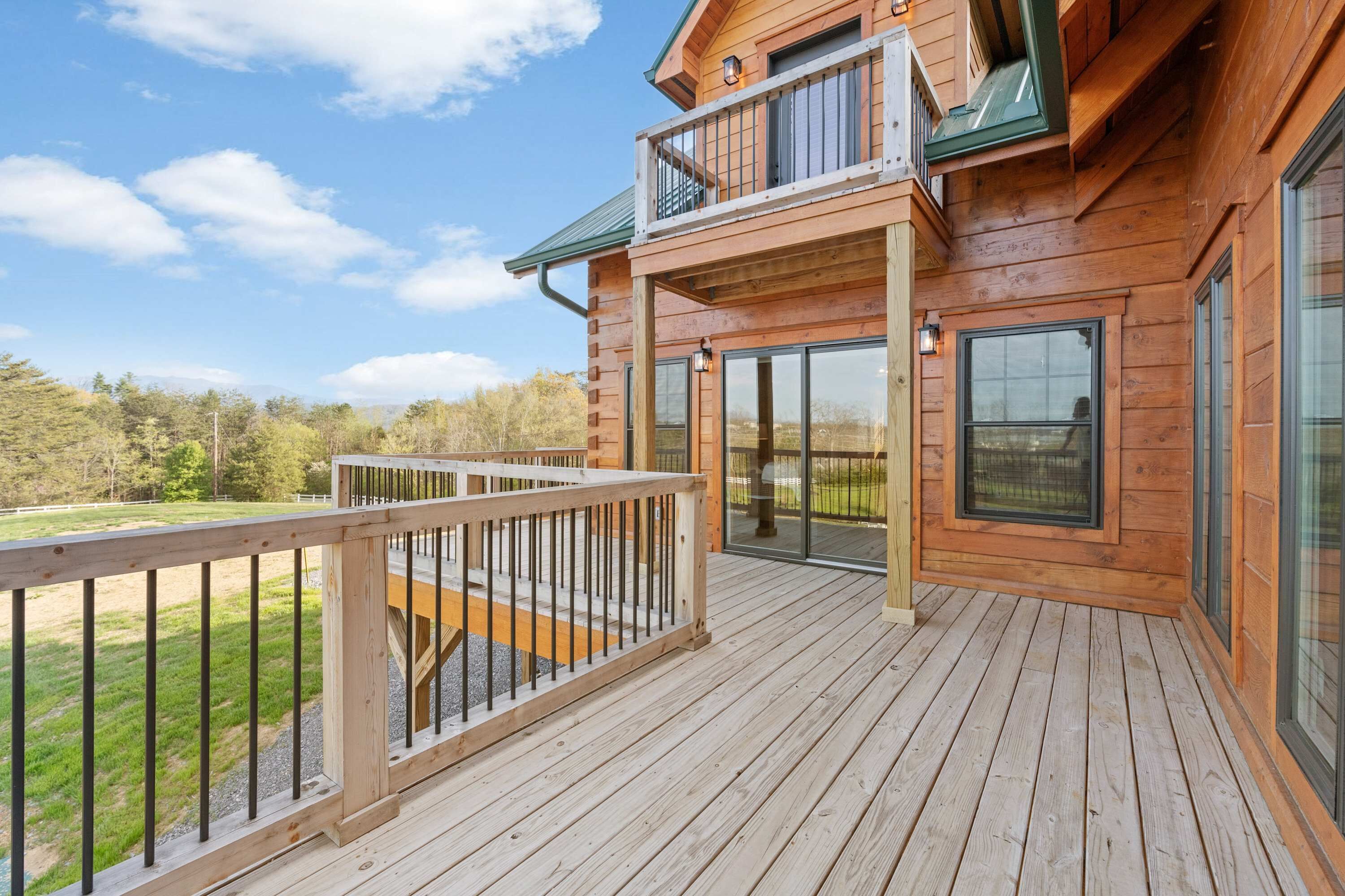 Una baita di legno con veranda, ampie finestre e balcone.
