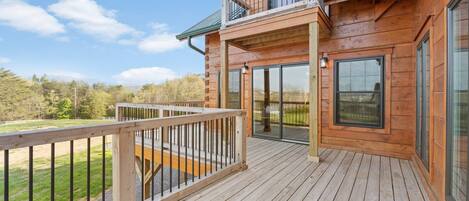 Una baita di legno con veranda, ampie finestre e balcone.