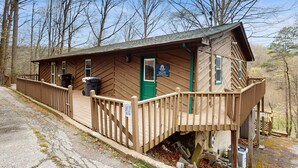 Eine Holzhütte mit Veranda, Tür und einem Schild, das eine Raststätte kennzeichnet.