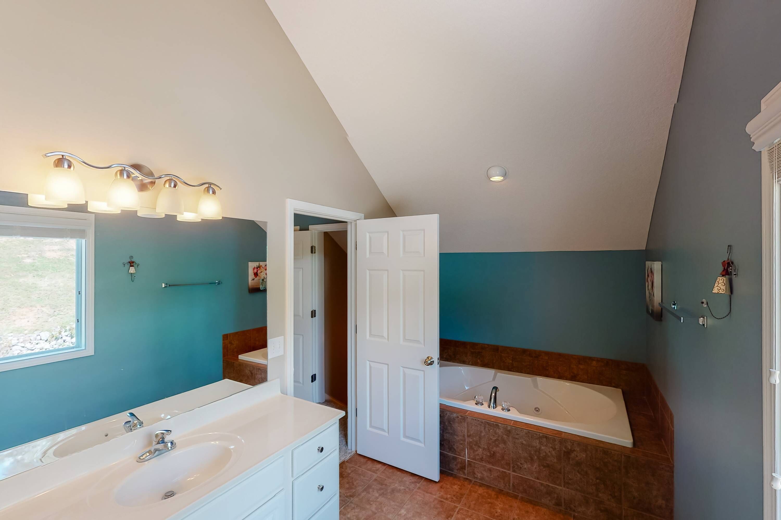 A modern bathroom with a large bathtub, a double sink vanity, and a walk-in shower.