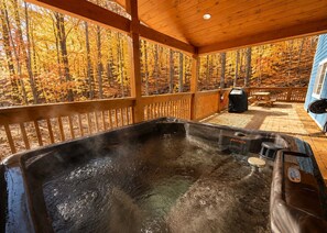 A hot tub on a wooden deck with a view of autumn trees. - Woodland Cottage Retreat・Hot Tub・Grill・Fireplace (Pigeon Forge)