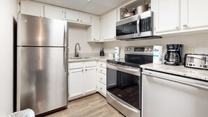 A modern kitchen with stainless steel appliances, white cabinets, and a skylight. - Dual-Suite Riverside Condo, Sleeps 4, Views, Pool (Pigeon Forge)