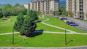 A multi-story residential building with a parking lot and green spaces. - Mtn View Getaway, Sleeps 6, Bunk nook, Shared Pool (Pigeon Forge)