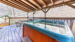 Ein Whirlpool auf einer Holzterrasse mit einer überdachten Holzpergola.