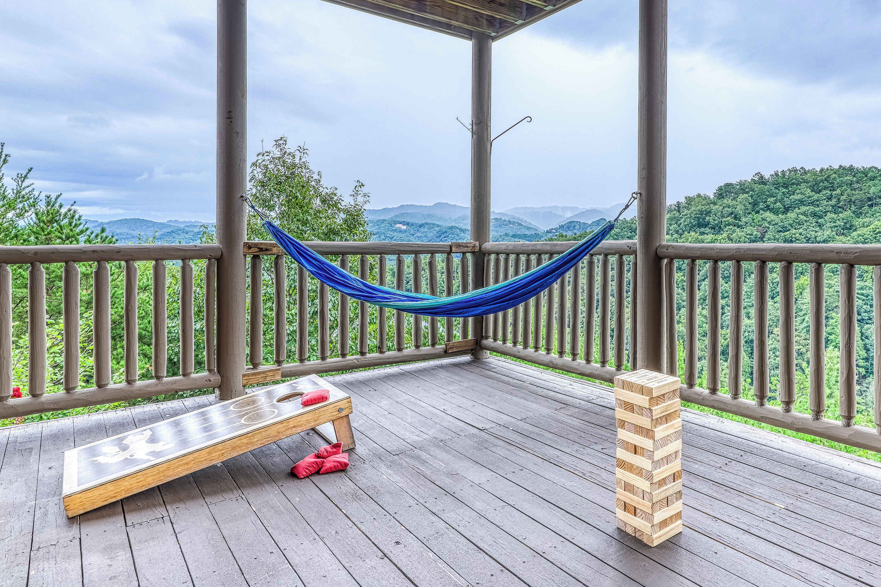 Een houten terras met een hangmat, een bank en een Jenga-toren.