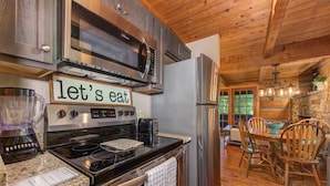 A modern kitchen with granite countertops, stainless steel appliances, and a wooden ceiling. - Dog Friendly Cabin, Sleeps 2・Screened Deck・Jet Tub (Sevierville)