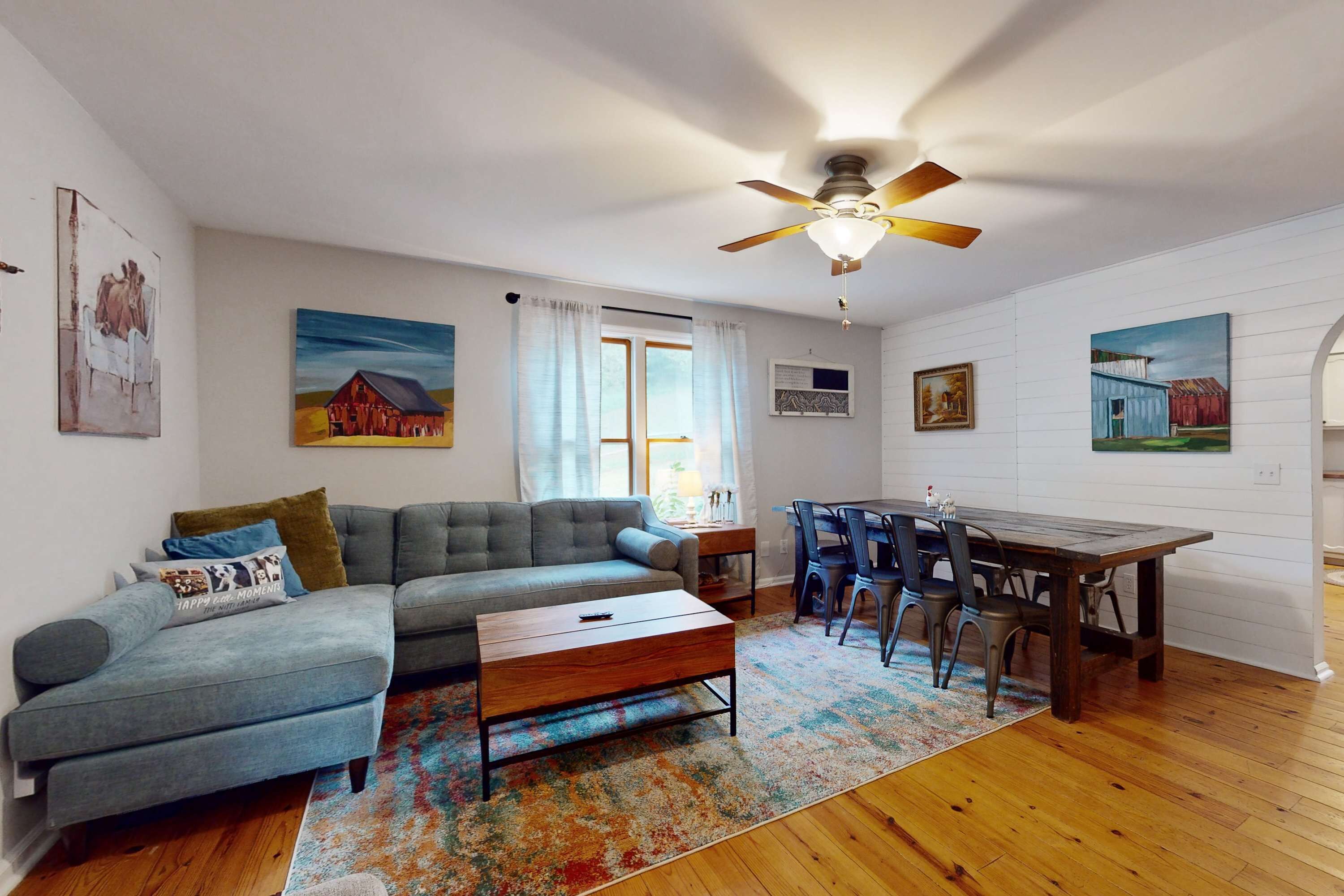 A living room with a sofa, coffee table, and dining table.