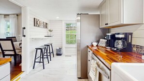 A modern kitchen with white cabinetry, a wooden countertop, and a coffee maker. - 11.4 Mi to Dollywood, Serene Country Stay・Fire pit (Sevierville)