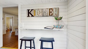 A kitchen with a 'KITCHEN' sign, two stools, and a shelf with a bowl and a tablet. - 11.4 Mi to Dollywood, Serene Country Stay・Fire pit (Sevierville)