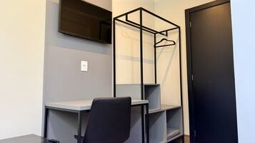 A compact room with a desk, chair, and built-in shelving unit.