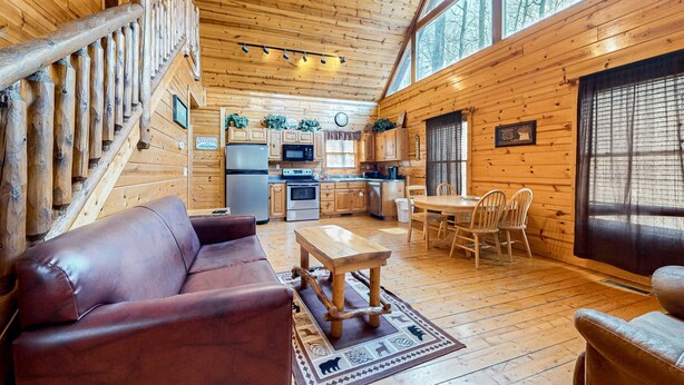 Ein Holzblockhaus mit Wohnzimmer, Küche und Essbereich.