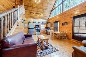 L'intérieur d'une cabane en bois comprend un salon, une cuisine et un coin repas.