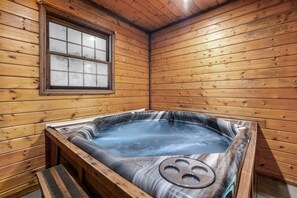 A wooden cabin with a hot tub, a window, and a bench. - Firepit, Hot Tub Under the Stars, Mountain Views (Sevierville)