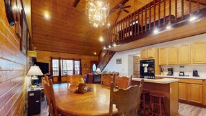 L’intérieur d’une cabane en bois comprend un coin repas, une cuisine et une chambre à coucher située en mezzanine.