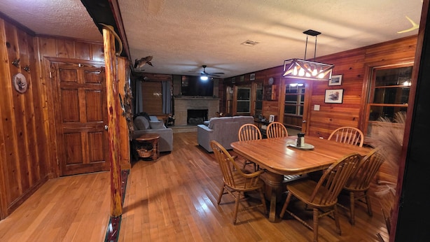 Ein Holzinterieur mit Esstisch, Stühlen, einer Couch und einem Kamin.