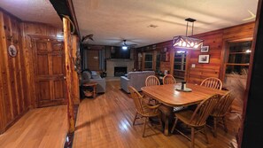 Un intérieur en bois comprenant une table à manger, des chaises, un canapé et une cheminée.