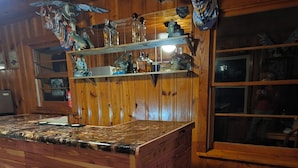 Eine Holzbar mit einer Arbeitsplatte und Regalen, die verschiedene Gegenstände zeigen.