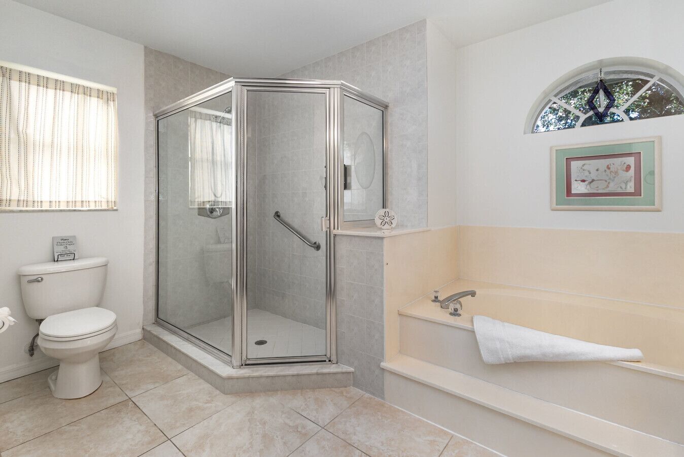 Elegant en-suite with spacious walk-in shower, separate soaking tub, and natural light for a bright, airy feel.