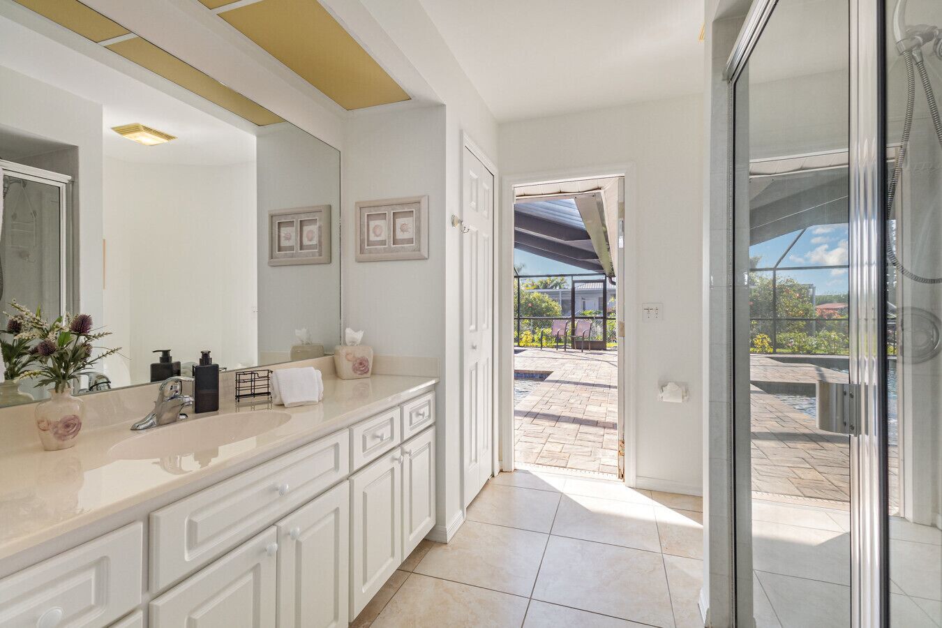 Light-filled guest bath with walk-in shower and direct access to the pool area — perfect after a swim.
