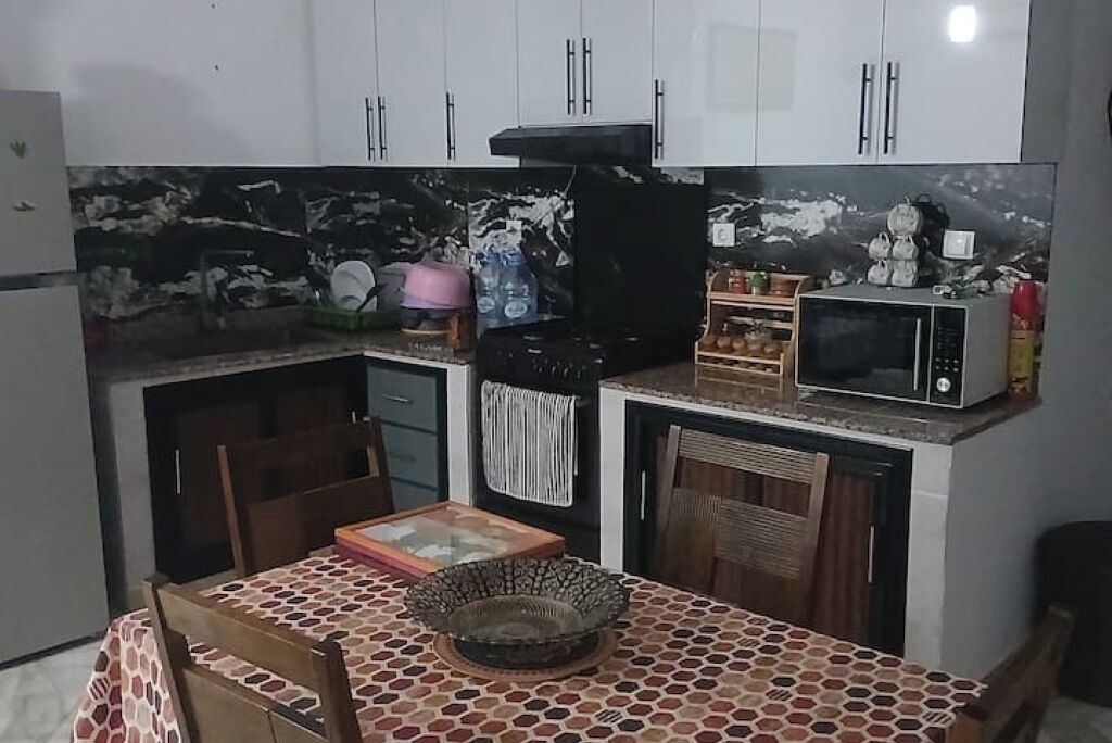 A compact kitchen with white cabinets, a microwave, and a sink.