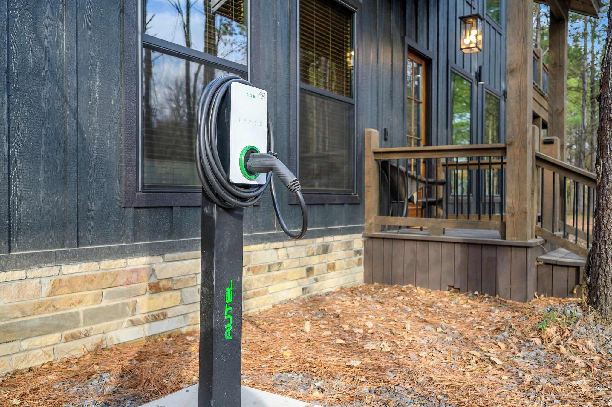 Una estación de carga para vehículos eléctricos montada en un poste, con el nombre de la marca "PULTEL" a la vista.