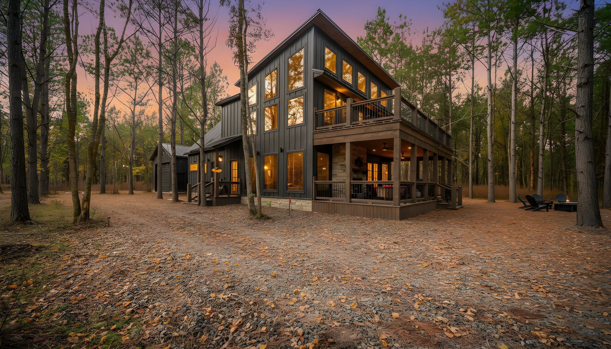 A multi-story cabin with a balcony, surrounded by a forest.