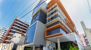 A modern building with multiple floors, large windows, and a distinctive architectural design. - Way Tambaú Suites (João Pessoa)