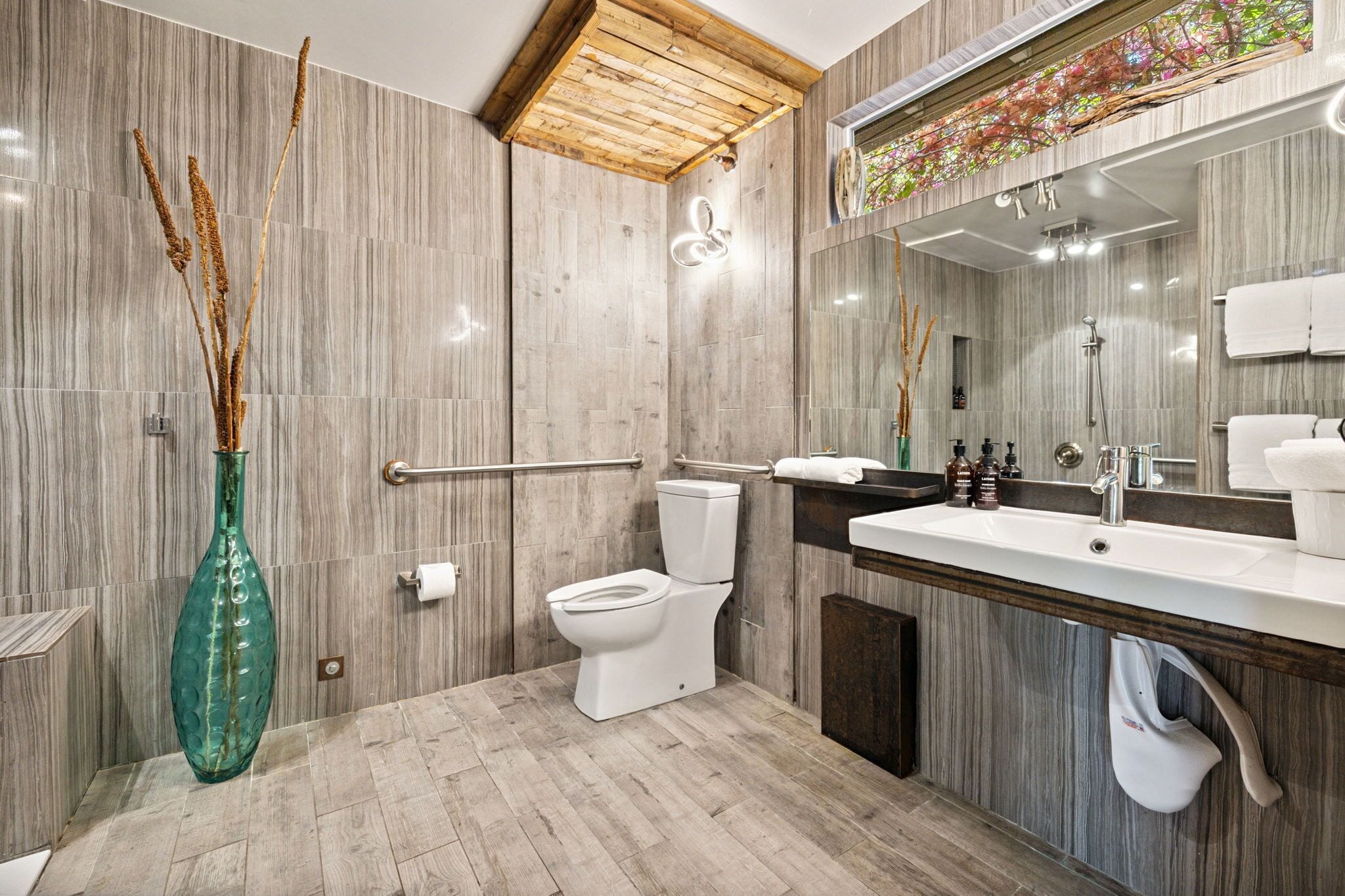 A modern bathroom with a toilet, sink, and shower.
