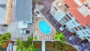 Vue aérienne d’un hôtel doté d’une piscine, d’un parking et d’un petit quai avec un bateau.