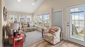 A spacious living room with a high ceiling, large windows, and a view of the outdoors. - Deep Water Access, Best Waterway Views, Pet-Friendly (Surf City)