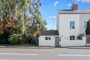 A two-story white house with a small front porch, a mailbox, and a gated entrance. - Pet-friendly Stonehouse cottage, minutes to the M5 (Gloucestershire)