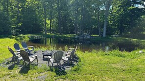A lakeside outdoor seating area with Adirondack chairs and a fire pit. - Fantastic 5-bedroom house with a pool in charming Clintondale (Clintondale)