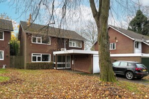 A two-story residential building with a covered porch and a car parked in the driveway. - Spacious 2 Bed Home with Parking Near City Centre (West Midlands)