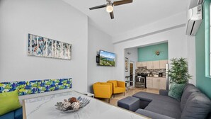 A modern living room with a marble coffee table, a sofa, and a TV mounted on the wall.