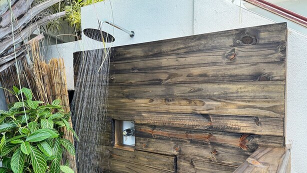 A wooden gate with a metal latch, a small window, and a vertical water feature. - Renovated Retreat by Condado Lagoon and Nightlife (San Juan)