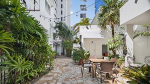 A courtyard with a stone-tiled floor, a table with chairs, and potted plants. - Condado Queen Studio, Near Beach & Dining (San Juan)