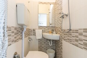 Economy tweepersoonskamer, voor 1 persoon | Badkamer | Een douche, een haardroger, handdoeken, zeep