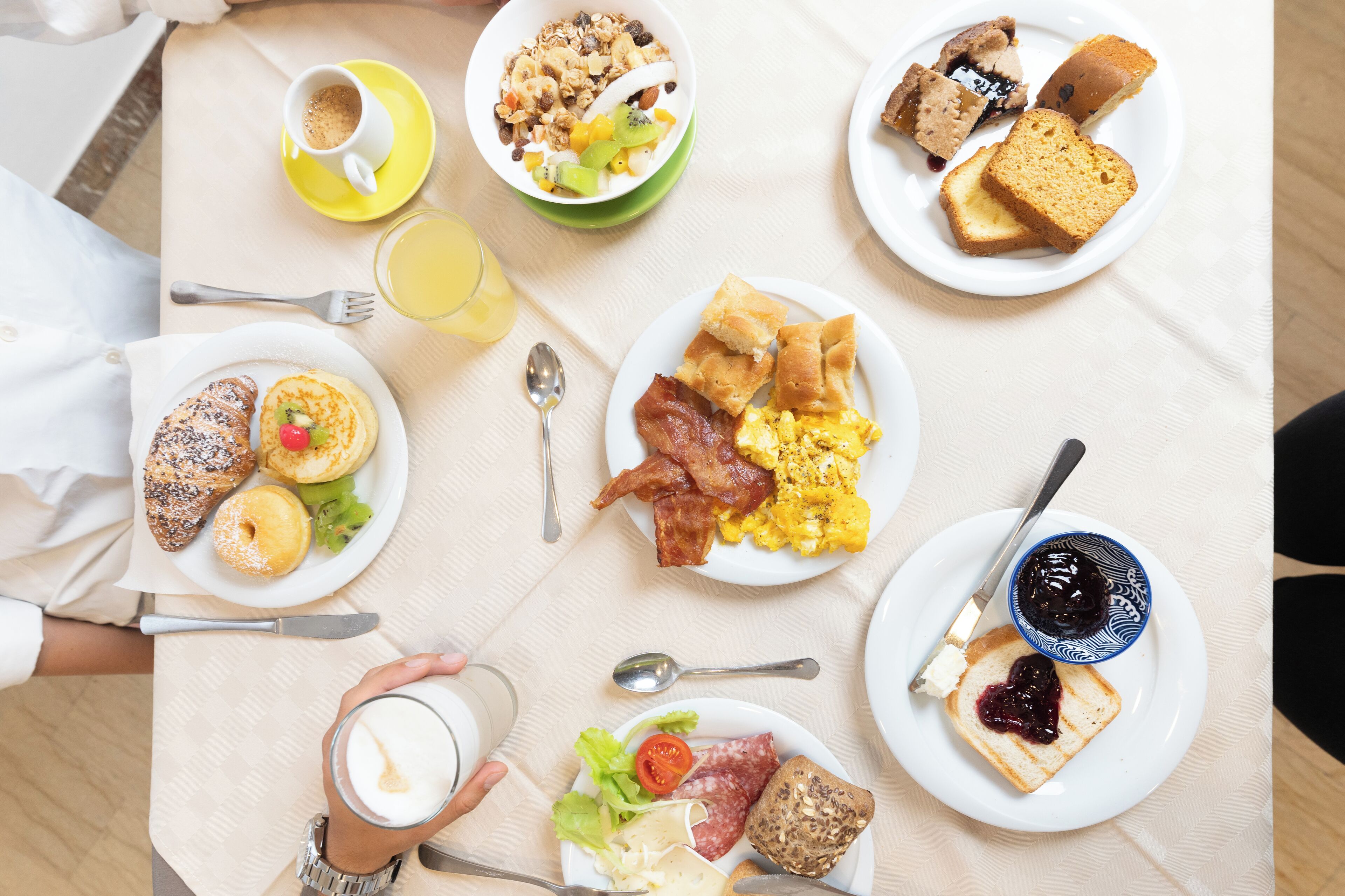 A breakfast buffet with various dishes including toast, eggs, and fruit.