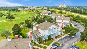 A residential area with houses, a golf course, and a distant building. - First Floor Resort Condo Poolside Oasis (Kissimmee)