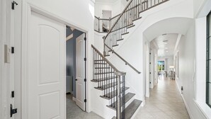 En rymlig hall med en svängd trappa som leder upp till andra våningen.