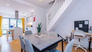 Ein modernes Interieur mit Essbereich, Küche und Treppe.