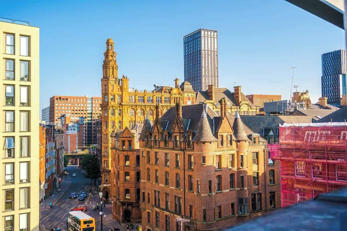 A historic building with a prominent tower, surrounded by modern high-rise buildings.