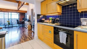 Une cuisine moderne avec des meubles en bois, un four noir et un dosseret de carrelage bleu.