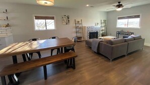 A spacious living area with a wooden dining table, a gray sofa, and a fireplace. - Charming 3-bedroom "The Rose House" in Marathon near Big Bend NP (Marathon)