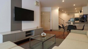 A modern living room with a flat-screen TV, a glass coffee table, and a sofa. - w* | Graceful 1BR with Balcony in Miraflores (Miraflores)