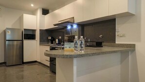 A modern kitchen with a built-in island, stainless steel appliances, and a granite countertop. - w* | Graceful 1BR with Balcony in Miraflores (Miraflores)