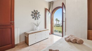 Una camera da letto con un letto, un comodino, una cassettiera, un elemento decorativo a parete e vista sull'esterno.