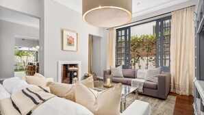 A modern living room with a sofa, coffee table, and a fireplace. - Bellevue House - Three Bedroom House, Sleeps 6 (Cape Town)